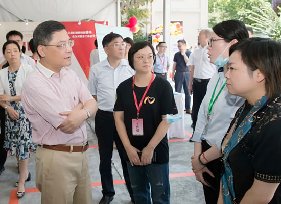 上海市副市长彭沉雷(左)等领导巡视福寿园公益发展基金会展位